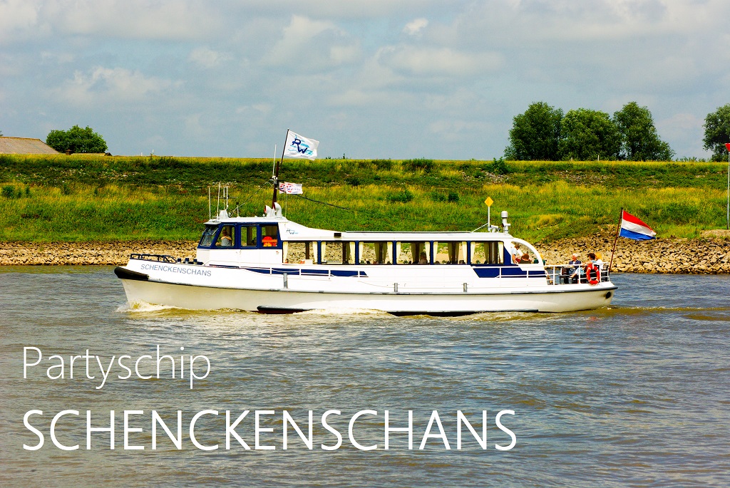 Partyschip Schenckenschans varend over de Rijn op een zonnige dag, met groene oever op de achtergrond en de Nederlandse vlag aan boord.
